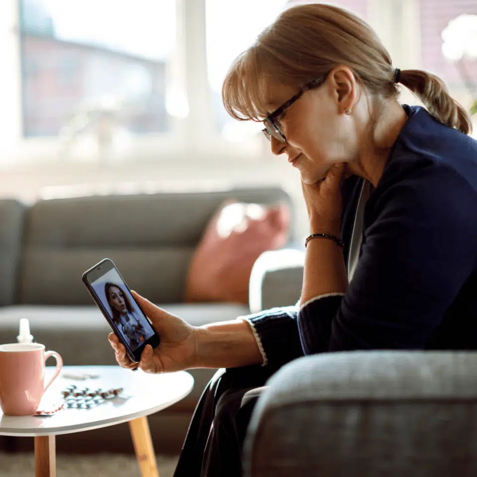 Femme en téléconsultation avec son médecin sur son téléphone